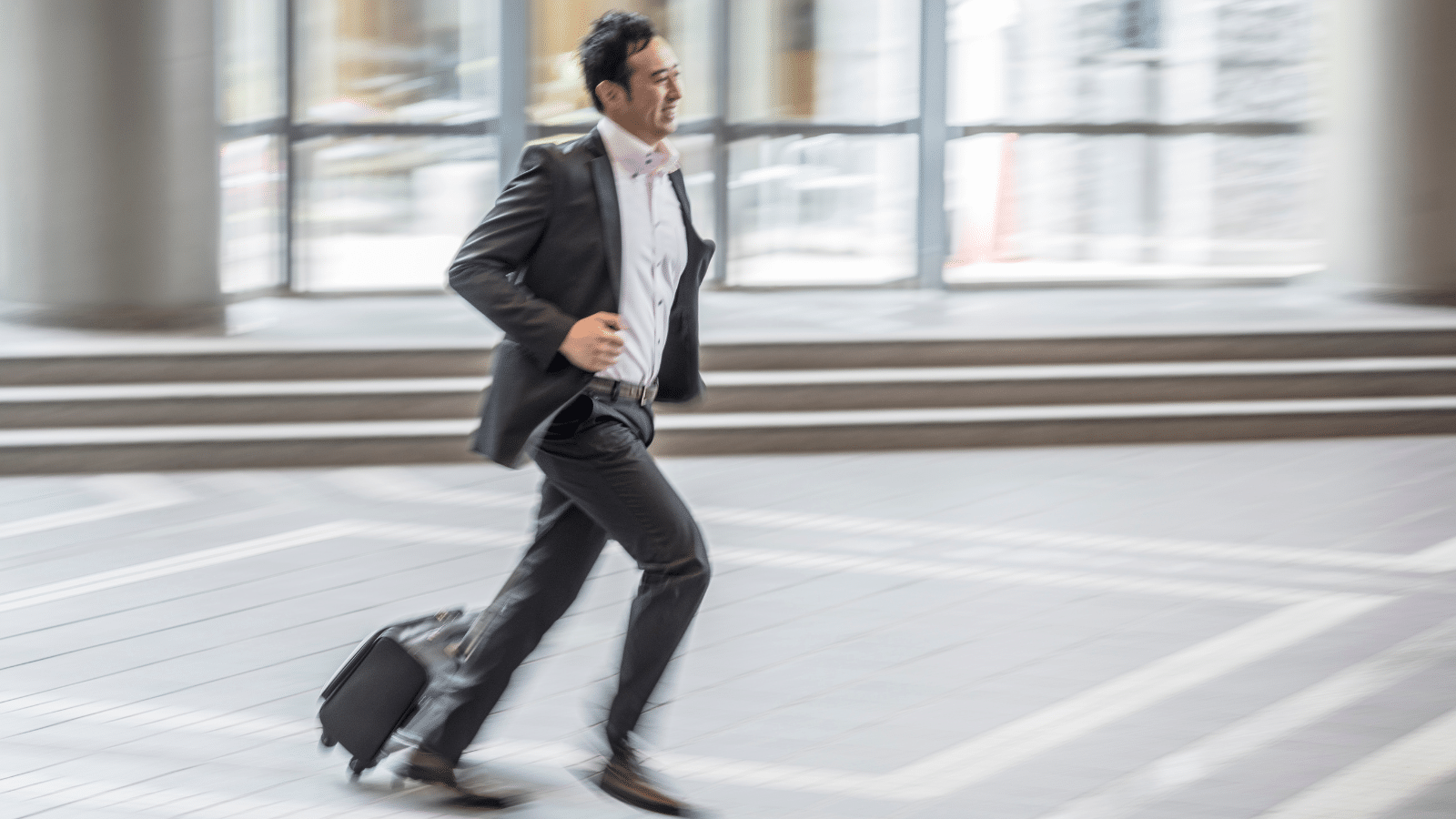 Businessman in suit running down a street